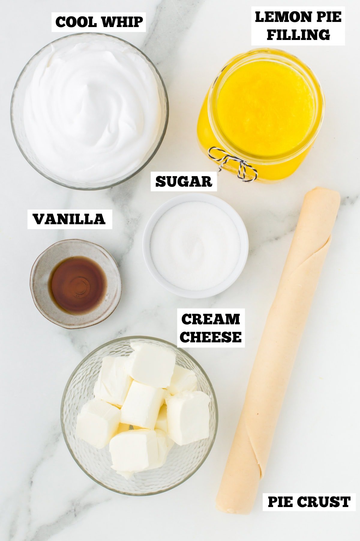A white board with bowls of ingredients needed to make a lemon and cream cheese layered pie.