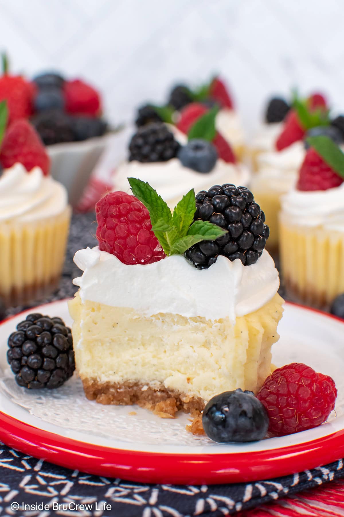 A muffin pan cheesecake cut in half showing the creamy center and cookie crust.