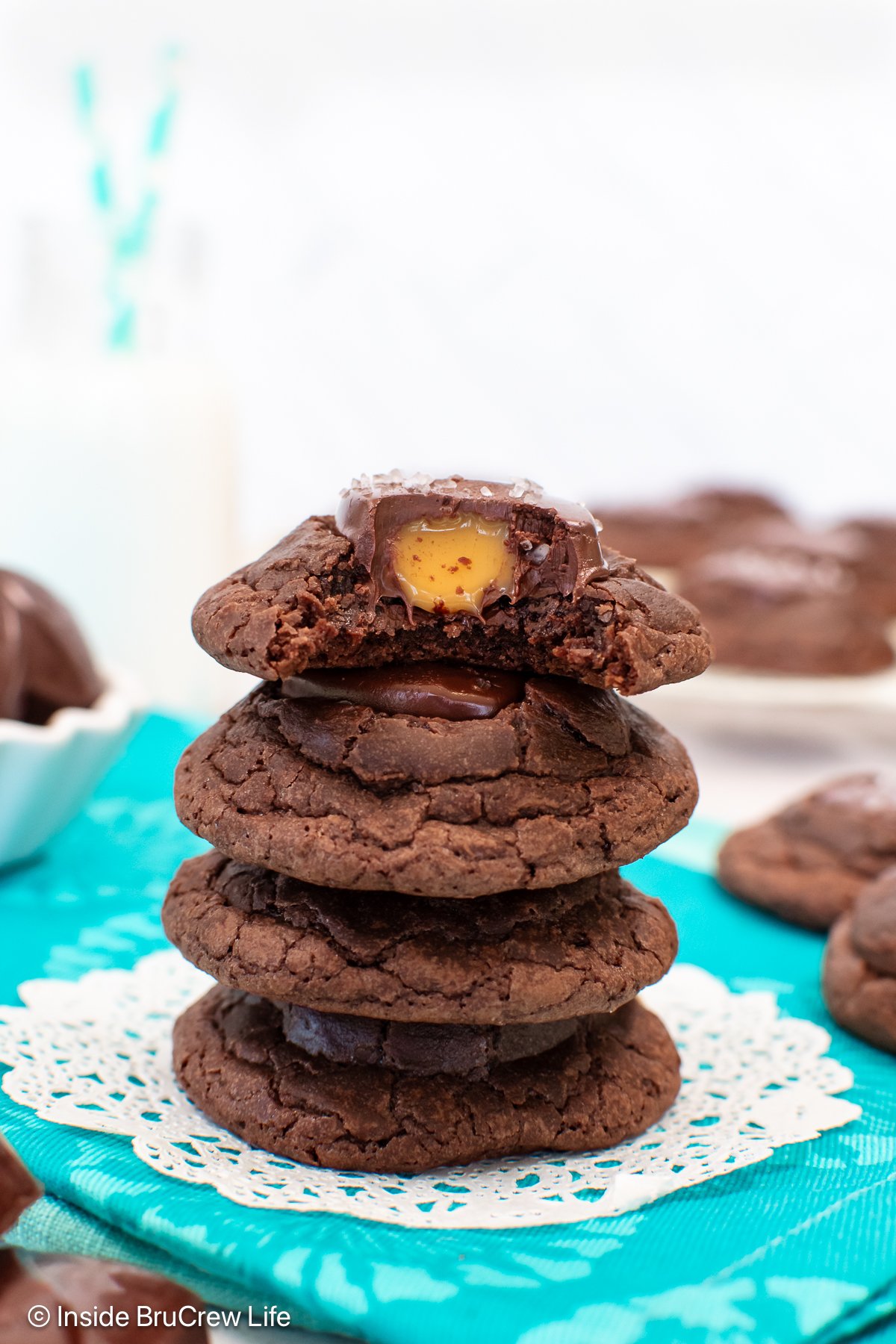 A stack of four caramel brownies cookies with the top one missing a bite.