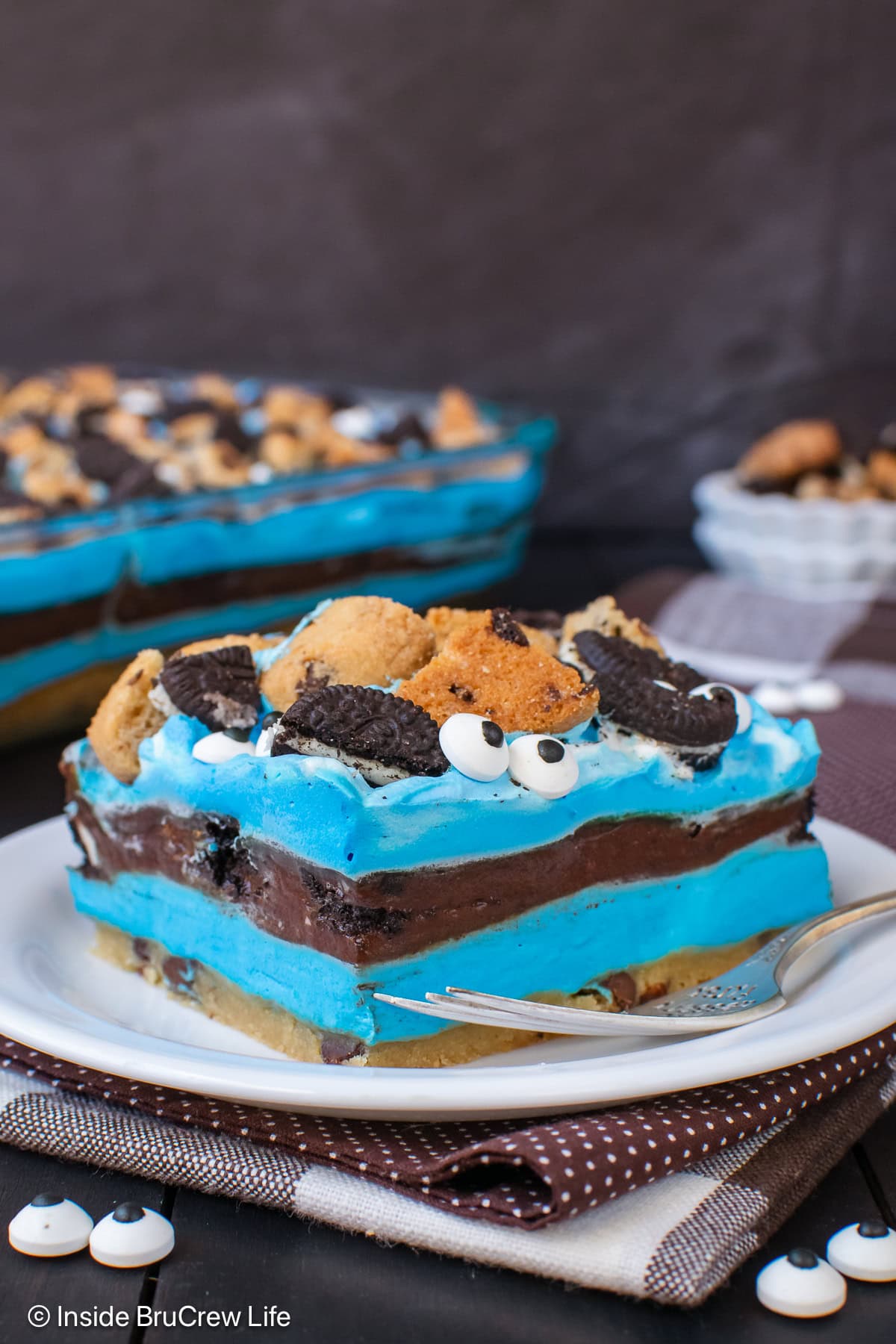 A square of cookie monster chocolate chip cookie dessert on a white plate.