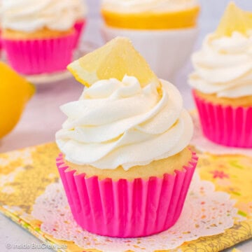 A cupcake in a pink wrapper with a swirl of lemon buttercream frosting.