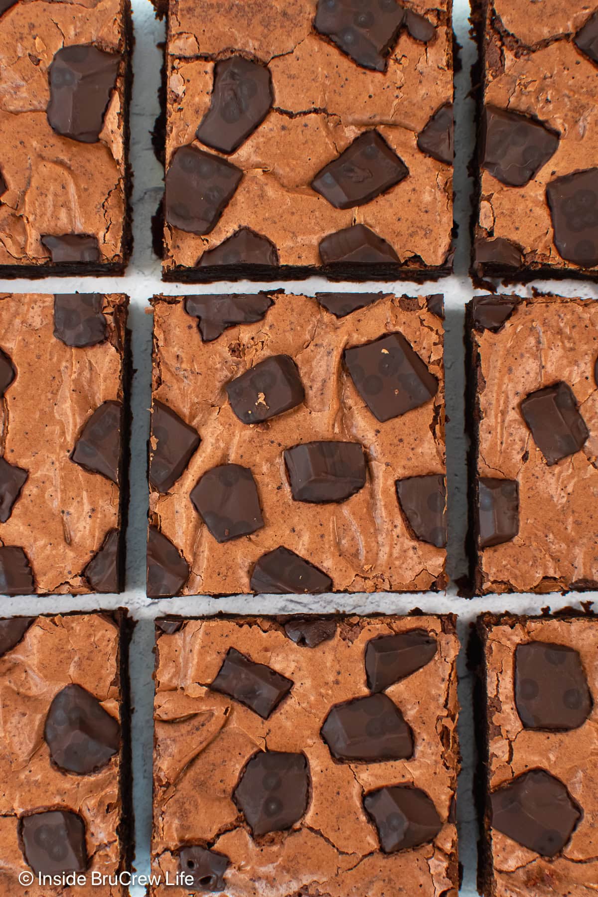 A close up of 9 double chocolate brownies with chunks.