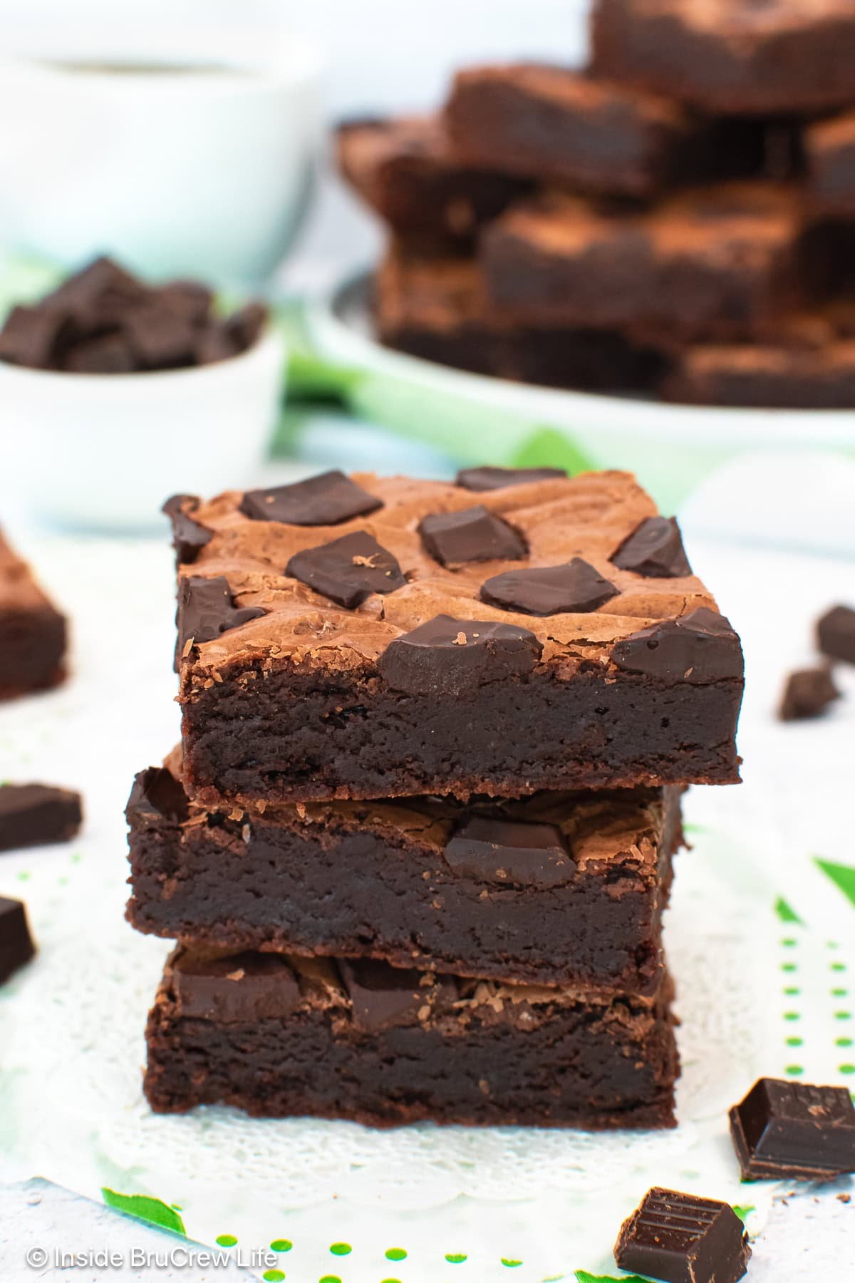 Three Starbucks copycat chocolate brownies stacked on a white board.