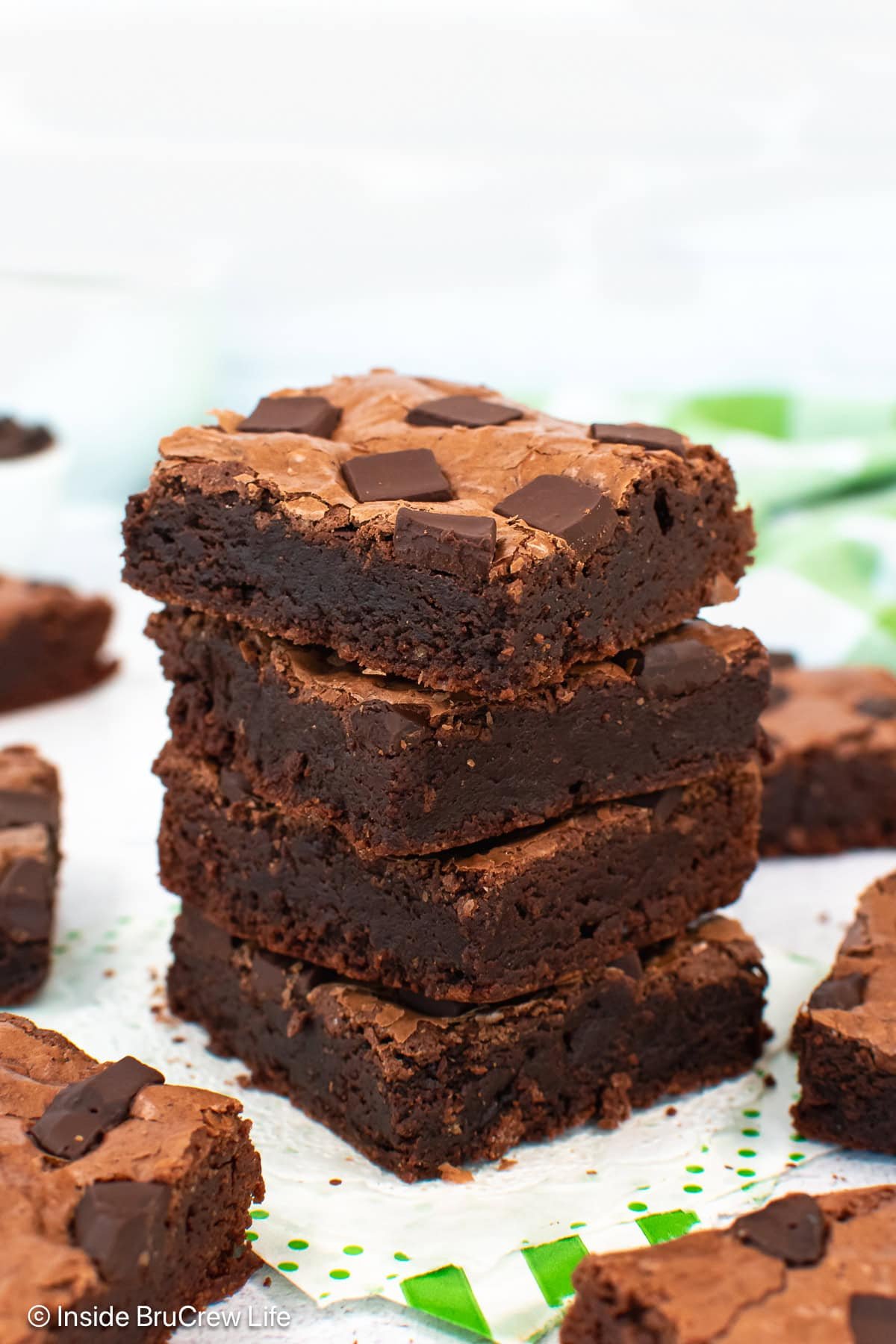 A stack of four double chocolate brownies on a white board.