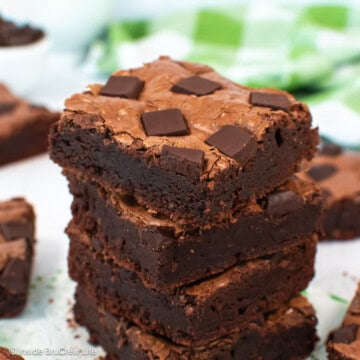 A stack of chocolate chunk brownies on a white board.