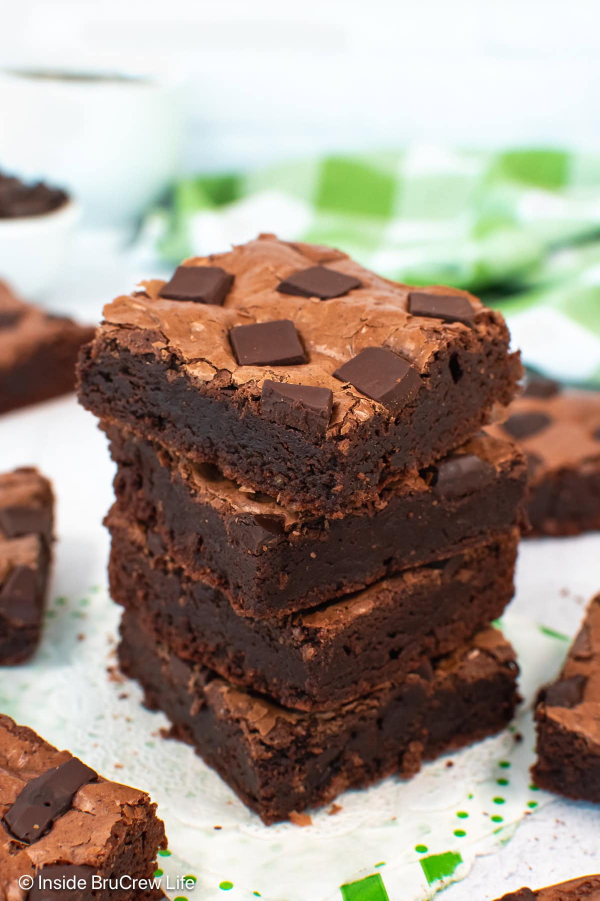 A stack of chocolate chunk brownies on a white board.