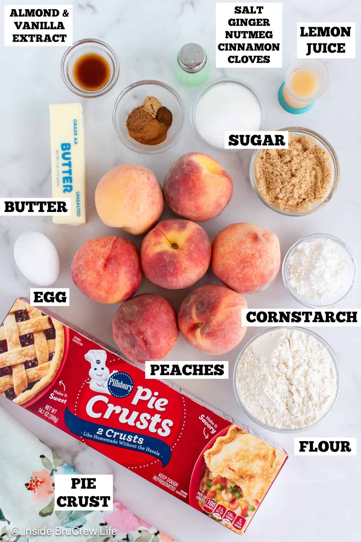 A white board with bowls of ingredients needed to make a peach pie with crumble topping.