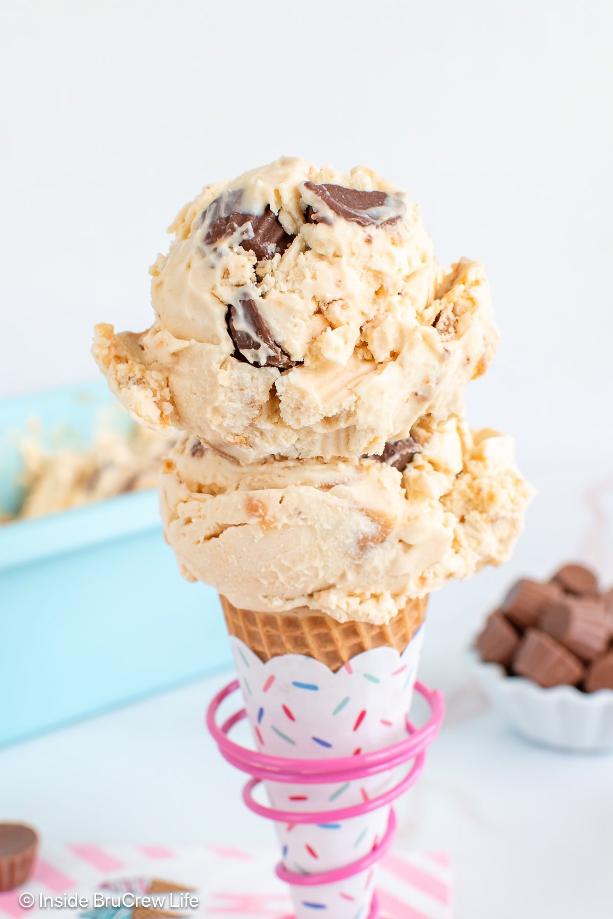 Two scoops of peanut butter ice cream on a sugar cone.