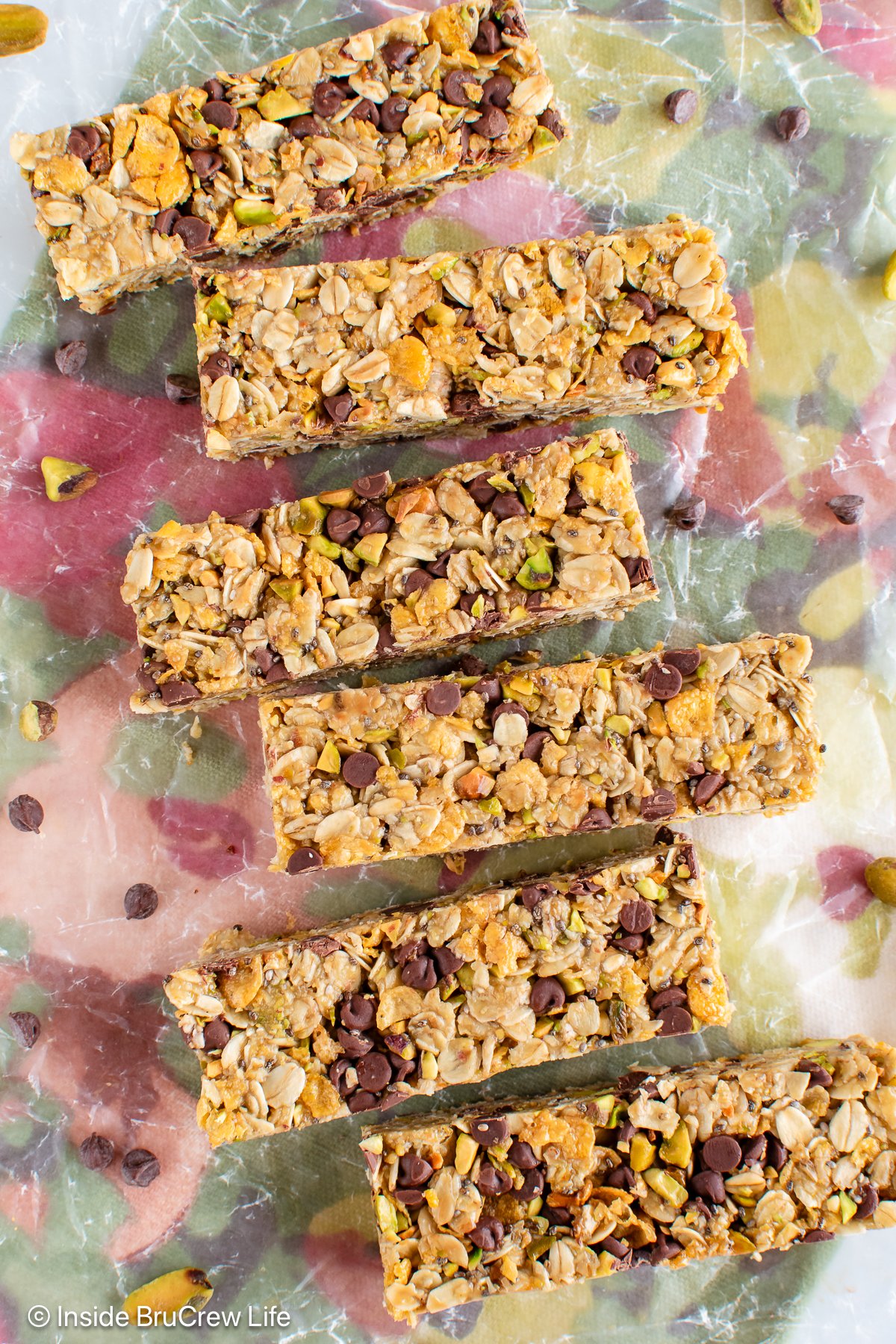 A line of chocolate chip pistachio granola bars on a towel.