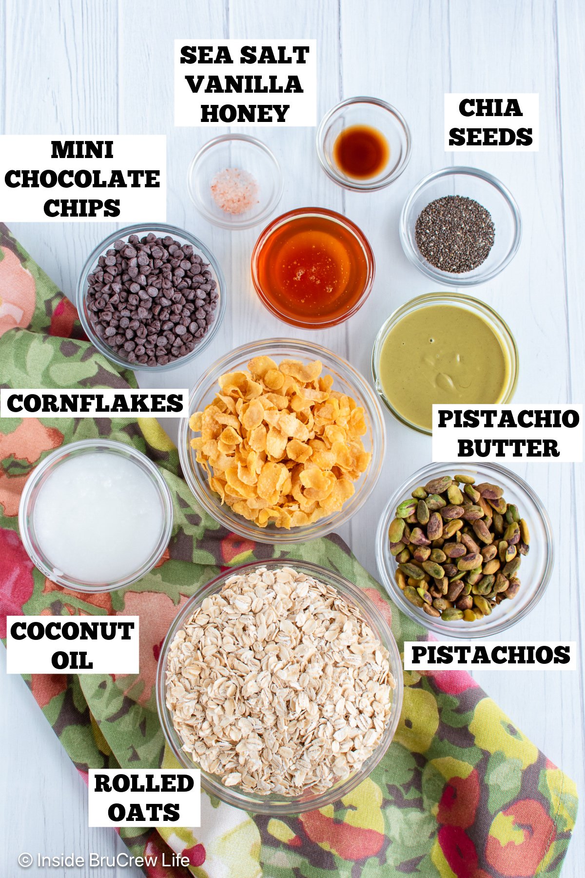 A white board with bowls of ingredients needed to make pistachio granola bars.