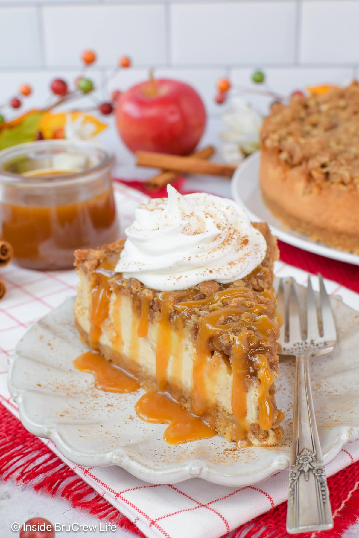 A slice of apple crisp cheesecake on a white plate.