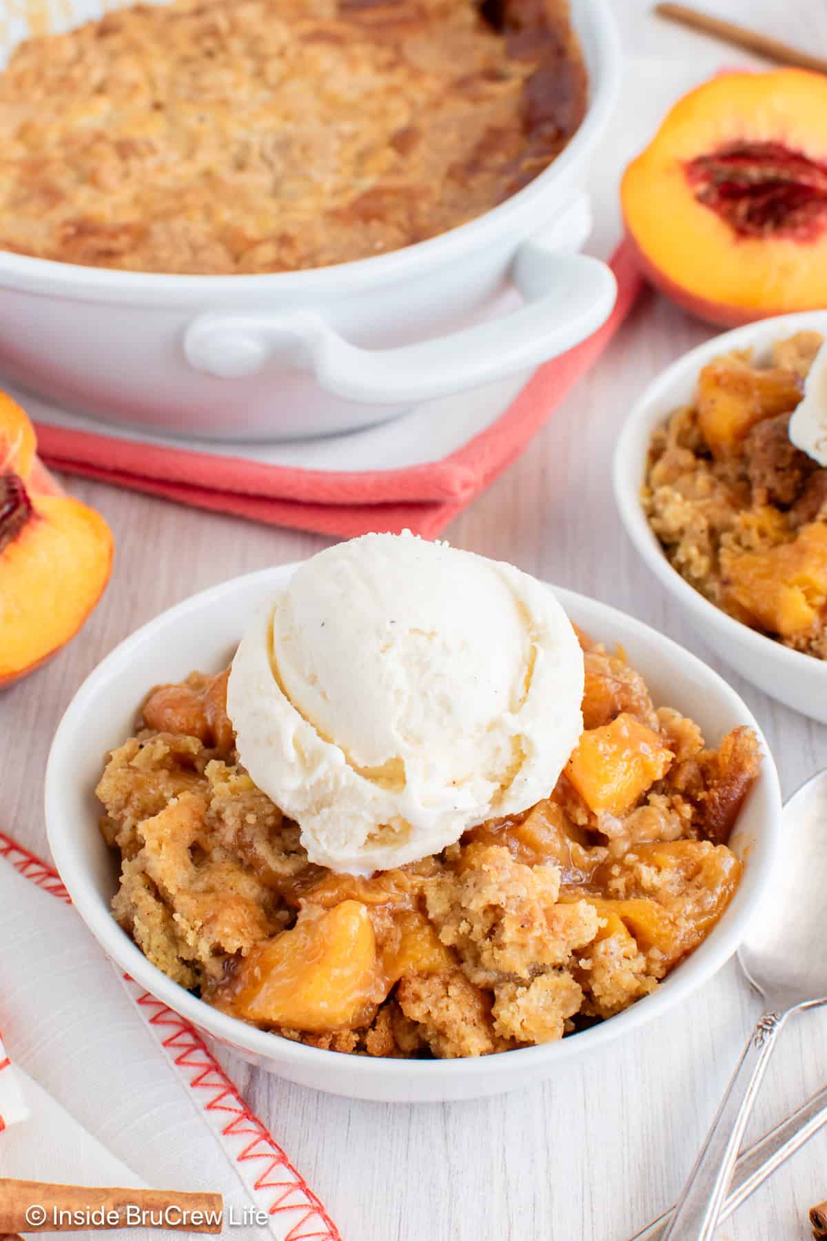 A bowl of peach dump cake with vanilla ice cream.