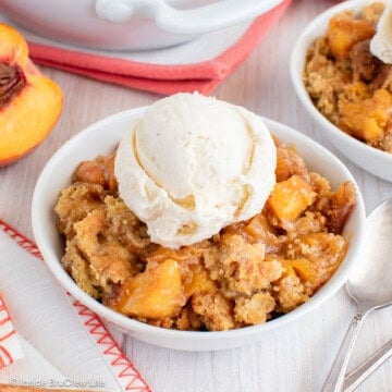 A bowl of peach dump cake with vanilla ice cream.