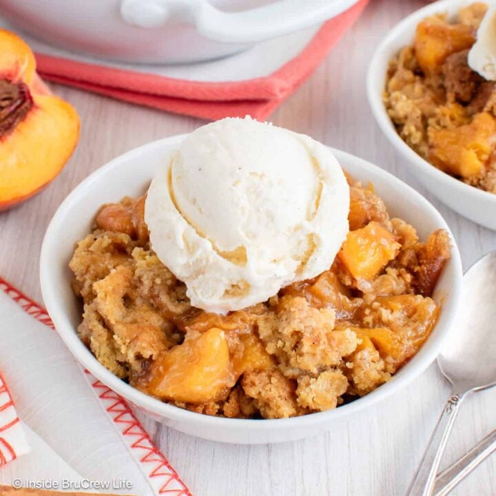 A bowl of peach dump cake with vanilla ice cream.