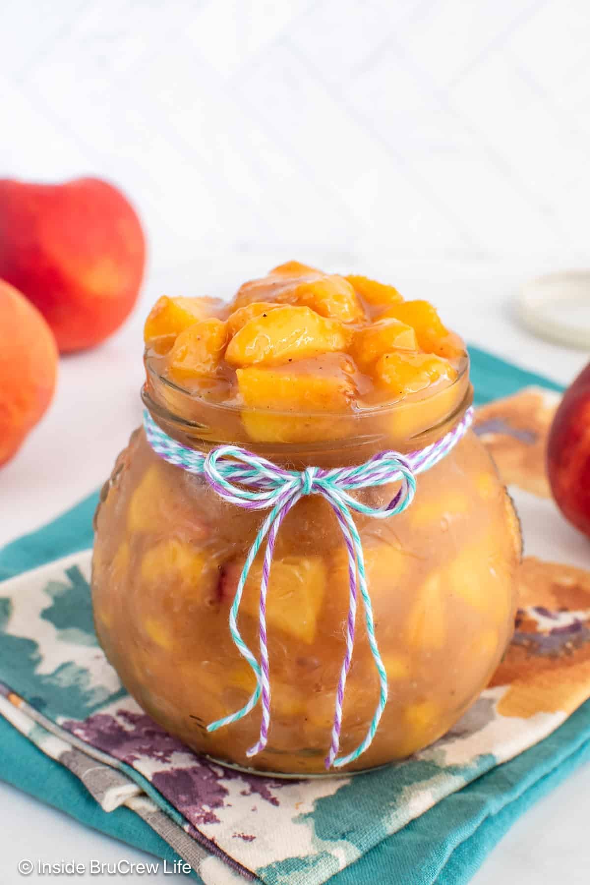 A clear jar filled with a fresh peach filling.
