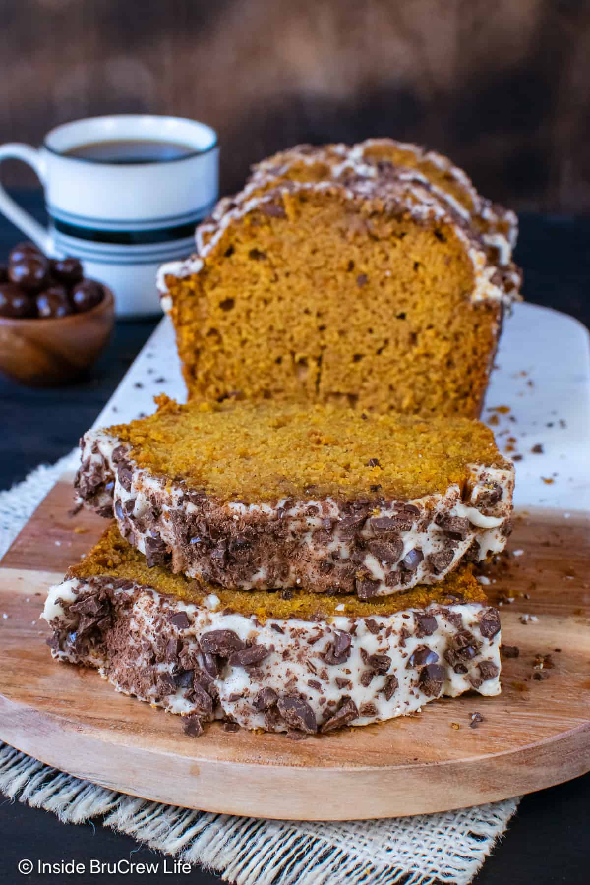 Pumpkin spice bread sliced and stacked on a cutting board.
