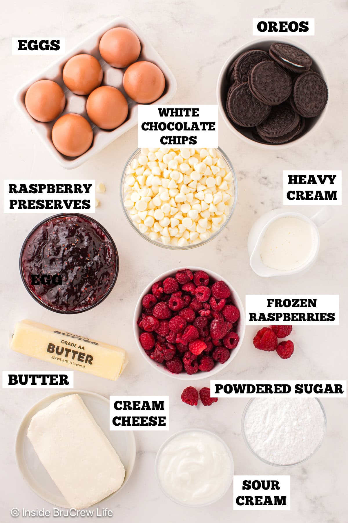 White chocolate raspberry cheesecake ingredients with text labels overlaying each ingredient.