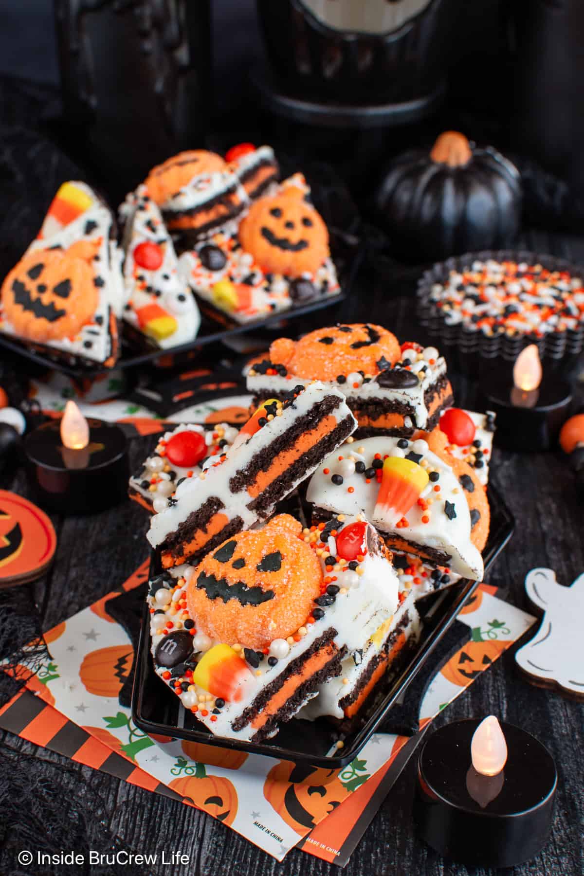 Two small black plates filled with pieces of Halloween bark.