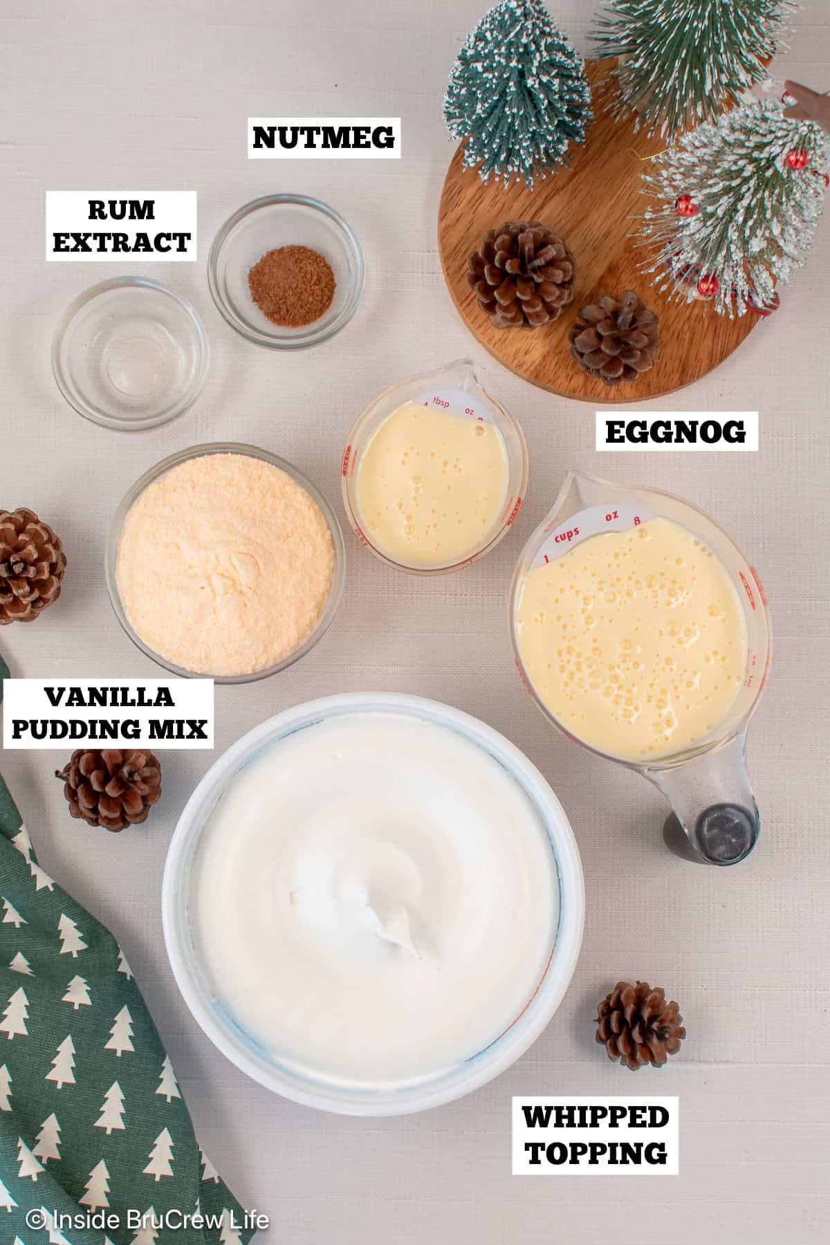 Light and fluffy eggnog dip is the easiest Christmas dessert made with instant pudding, eggnog, and whipped cream. It's ready in 10 minutes! Eggnog dip ingredients with text labels overlaying each ingredient.