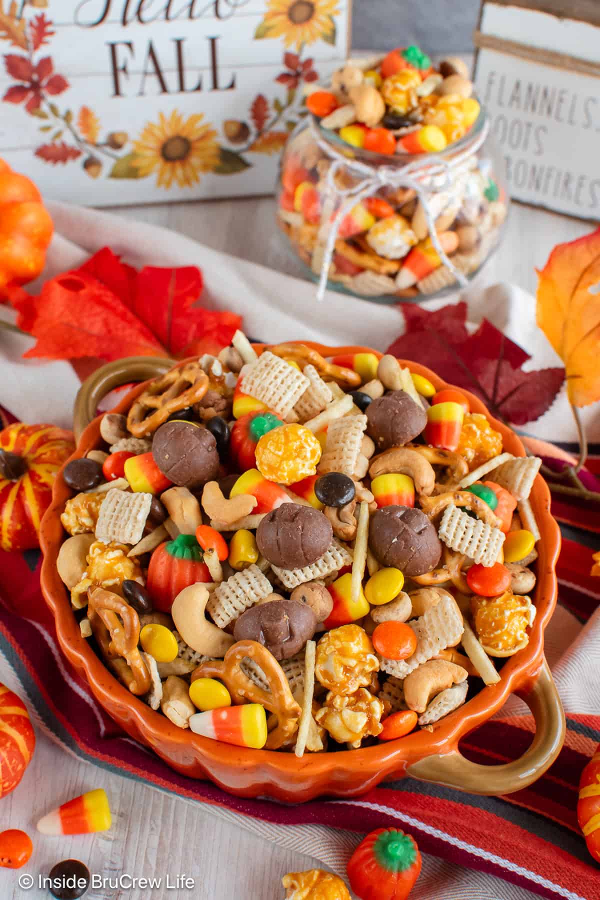 A sweet and salty fall snack mix in a orange bowl.