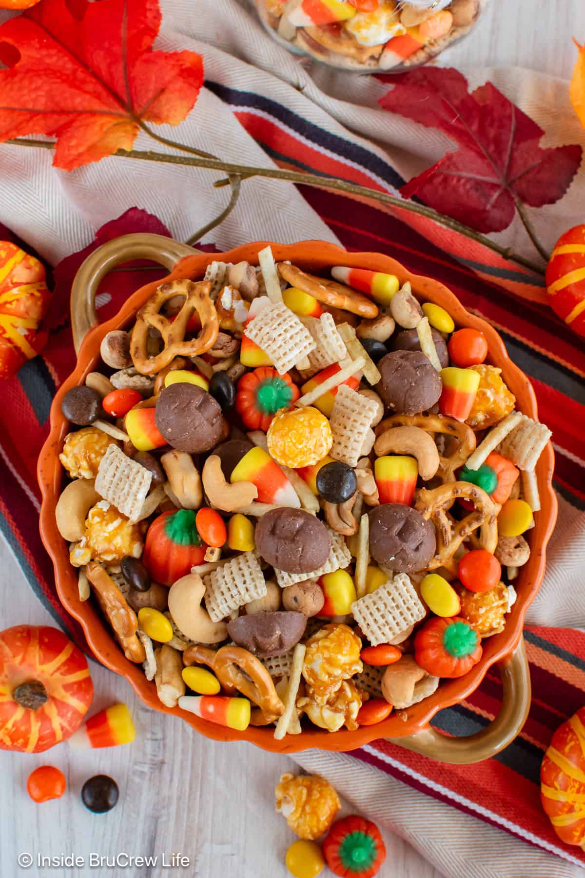 An overhead picture of an orange bowl filled with a fall snack mix.