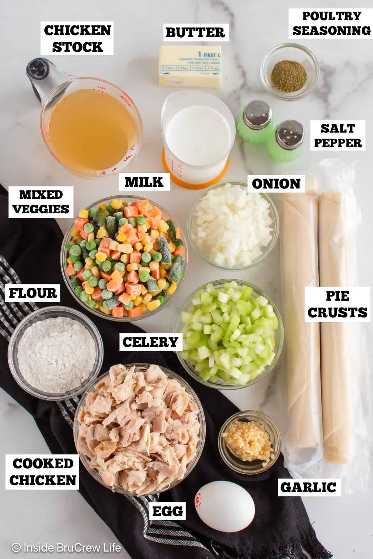 Homemade chicken pot pie ingredients on a board with labels.