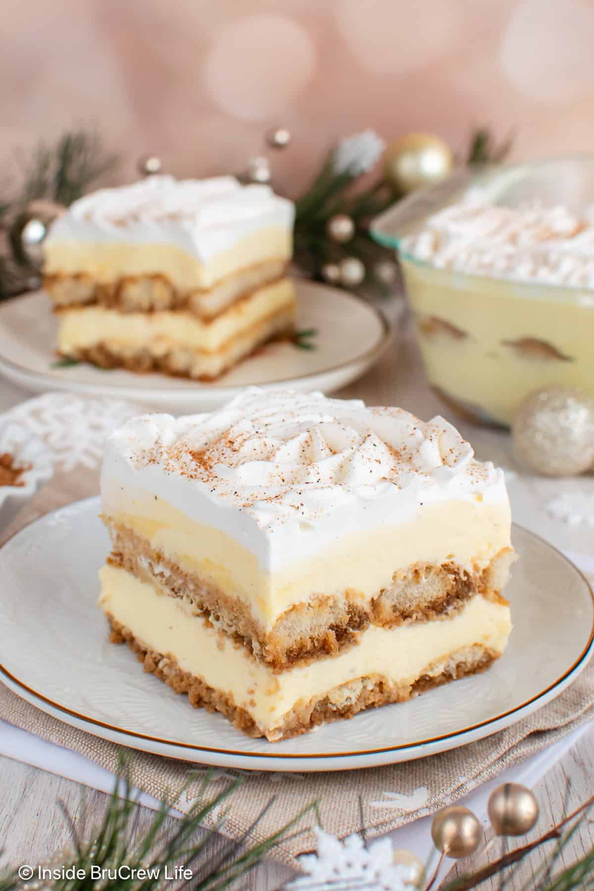 Two slices of eggnog tiramisu on white plates.