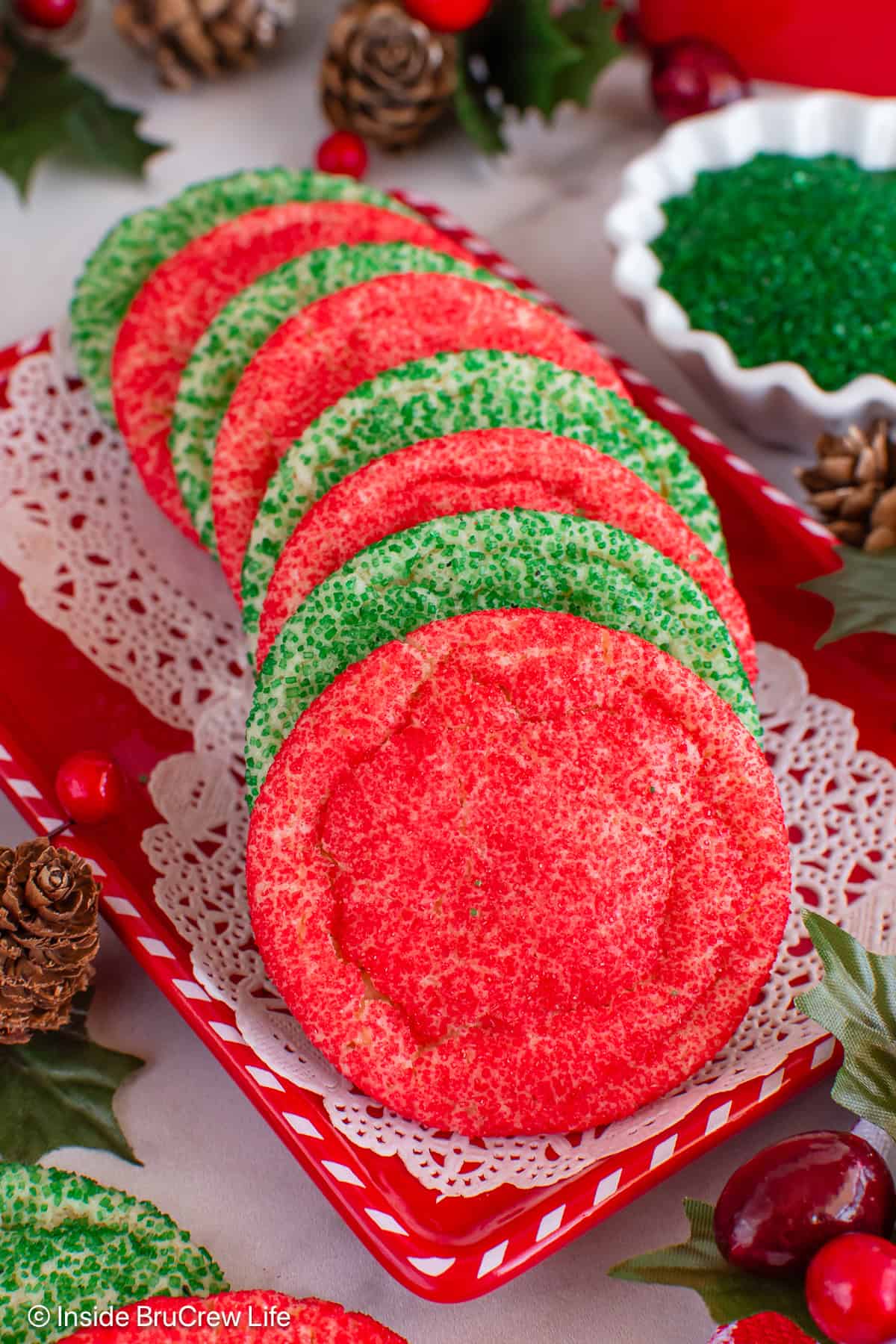A stack of red and green sugar cookies laying on a red tray.