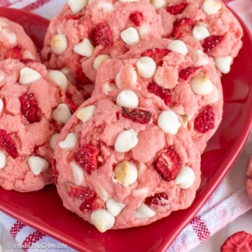 Strawberry cookies stacked on a red plate.