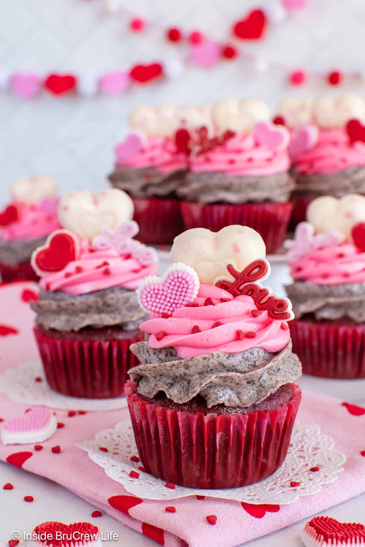 Valentine's cupcakes topped with pink frosting and extra heart toppers.