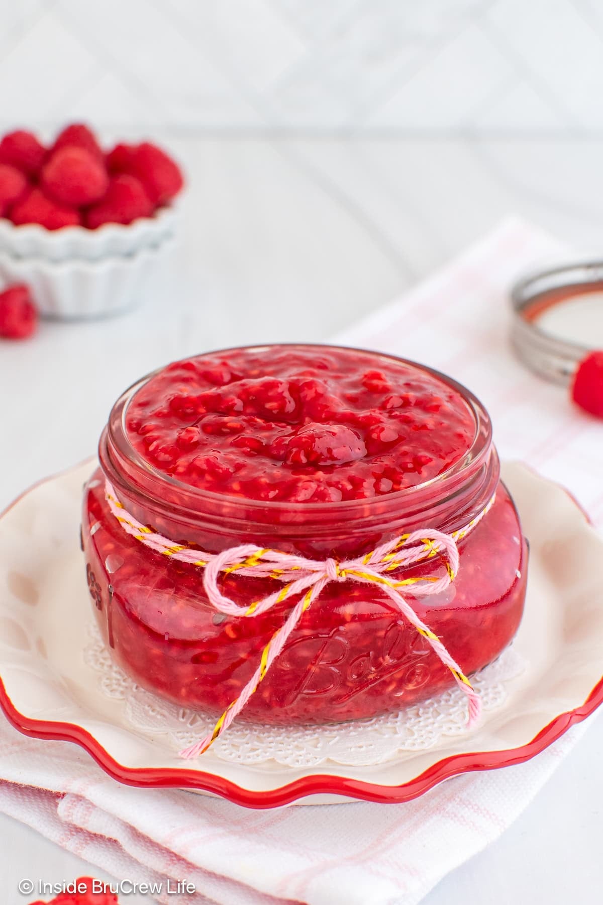 A glass mason jar filled with raspberry pie filling.