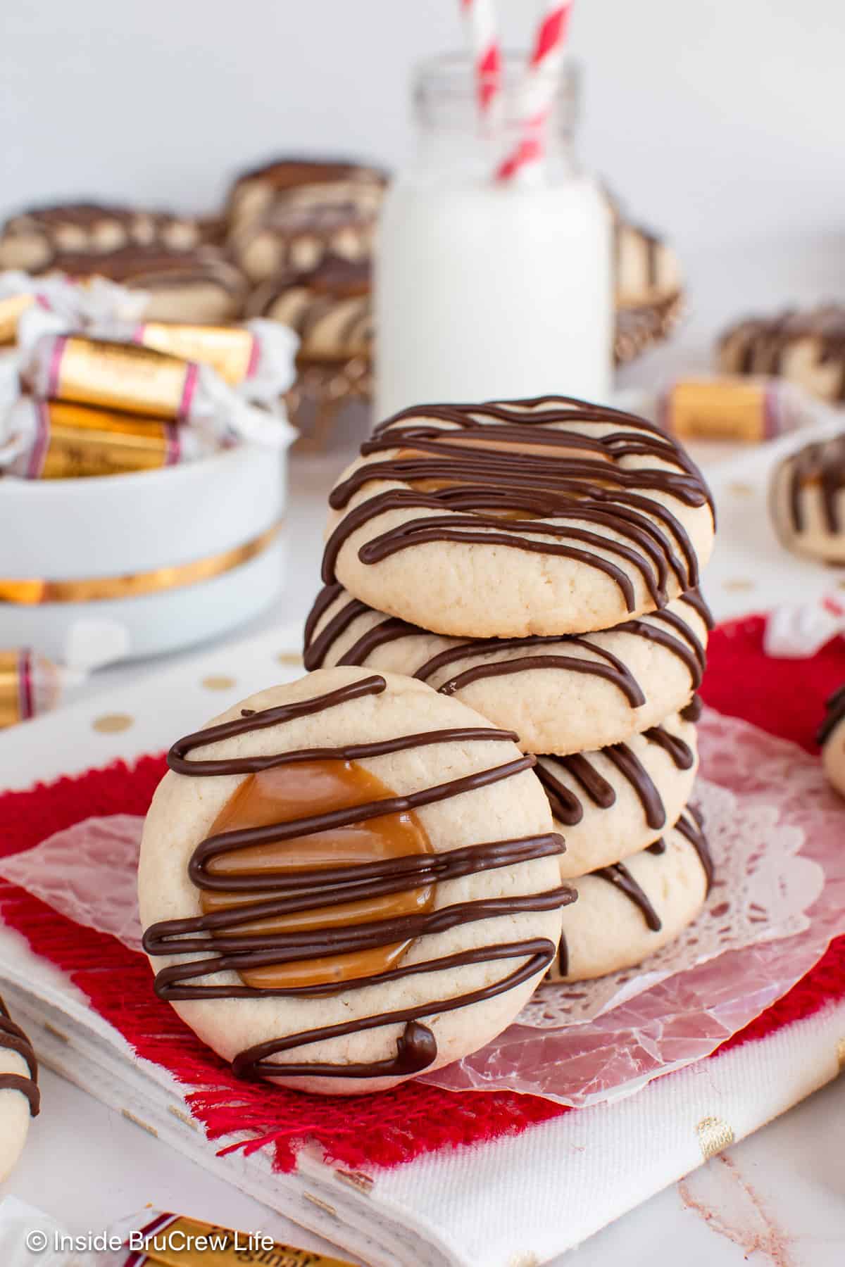 A stack of Twix thumbprint cookies with one standing beside it.