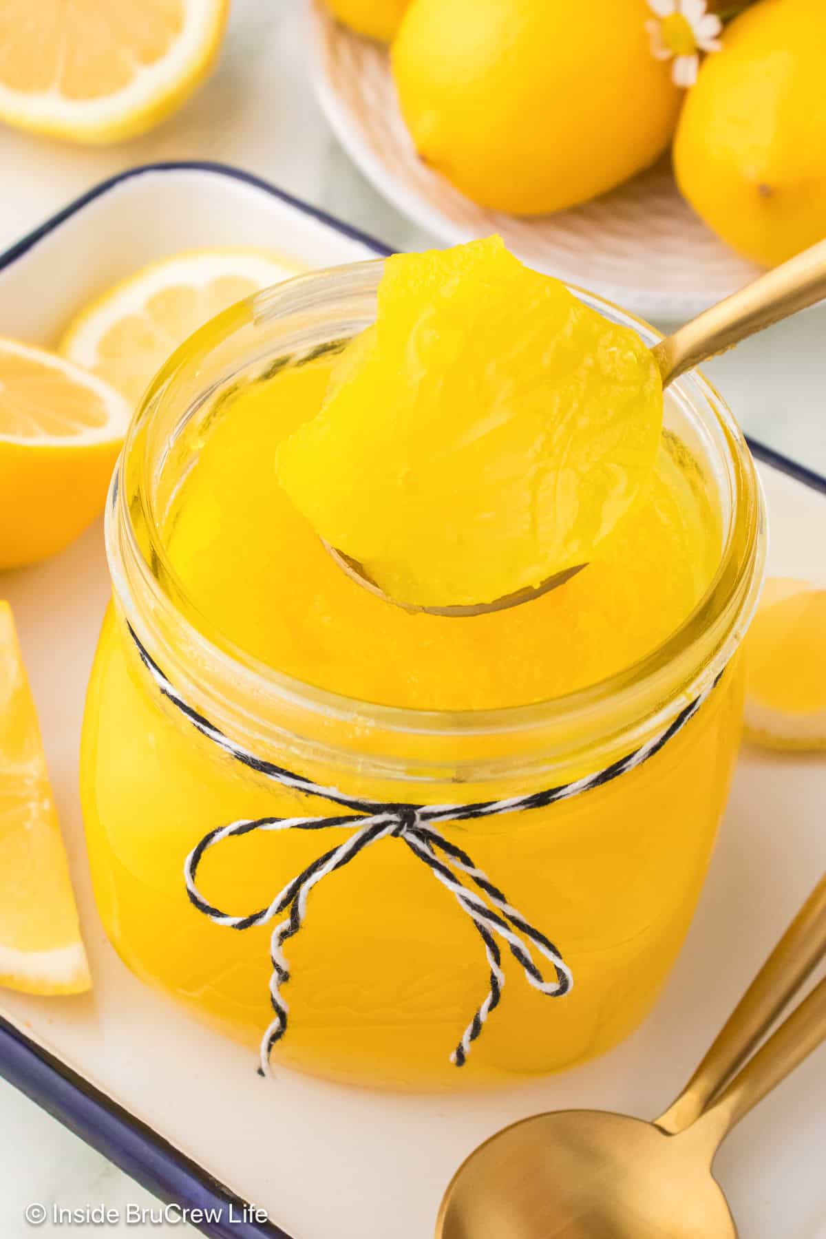 A jar of chilled lemon pie filling with a spoon lifting some out.