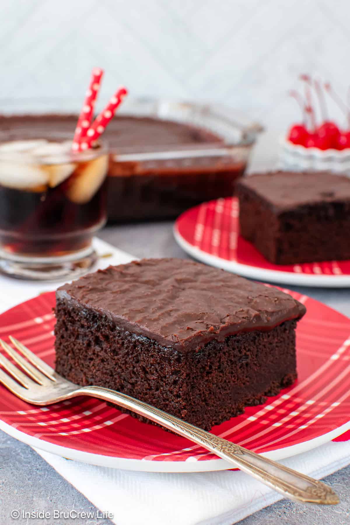 A square of coca cola cake on a red plate.