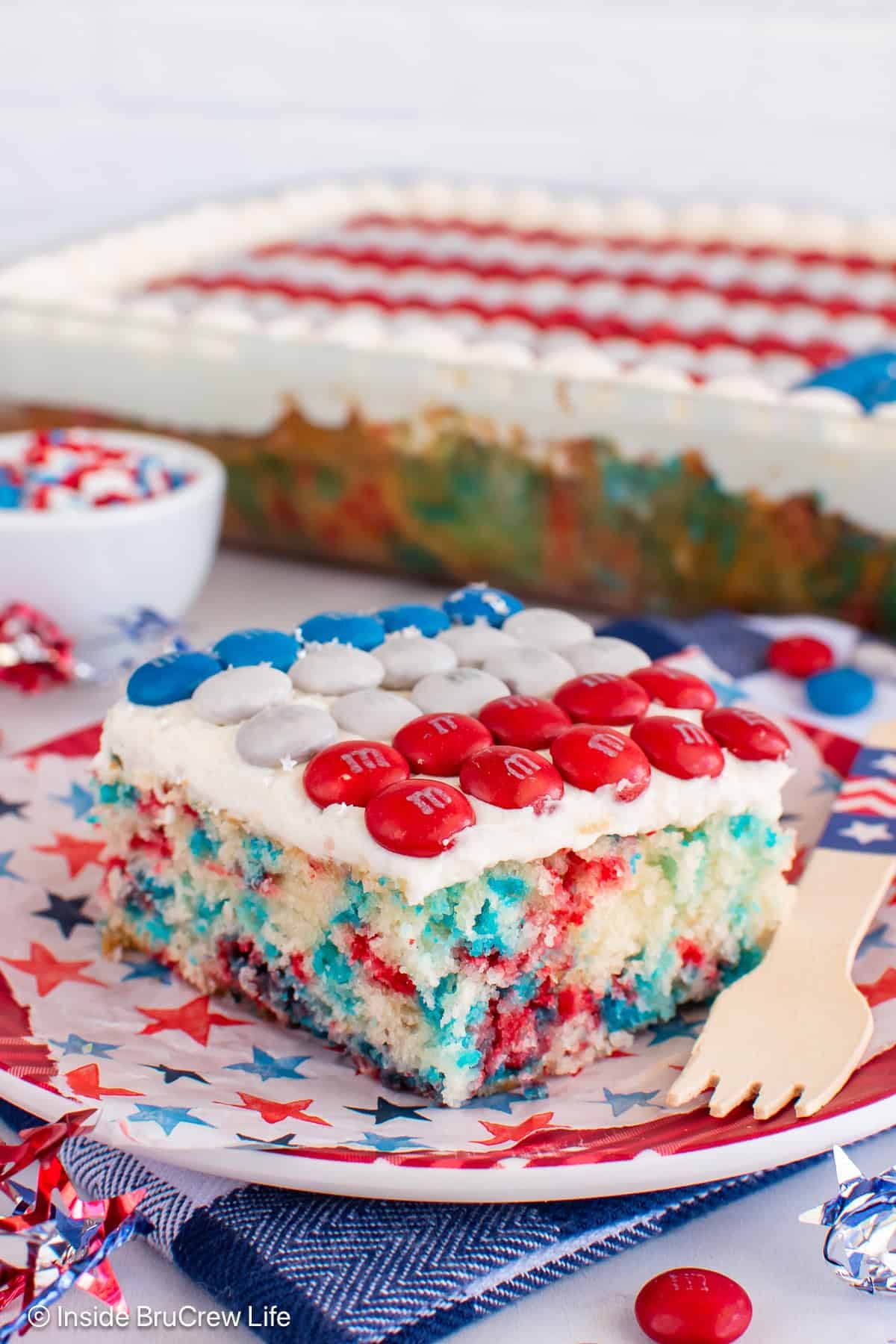 A red white and blue 4th of July cake with sprinkles and an M&M flag.
