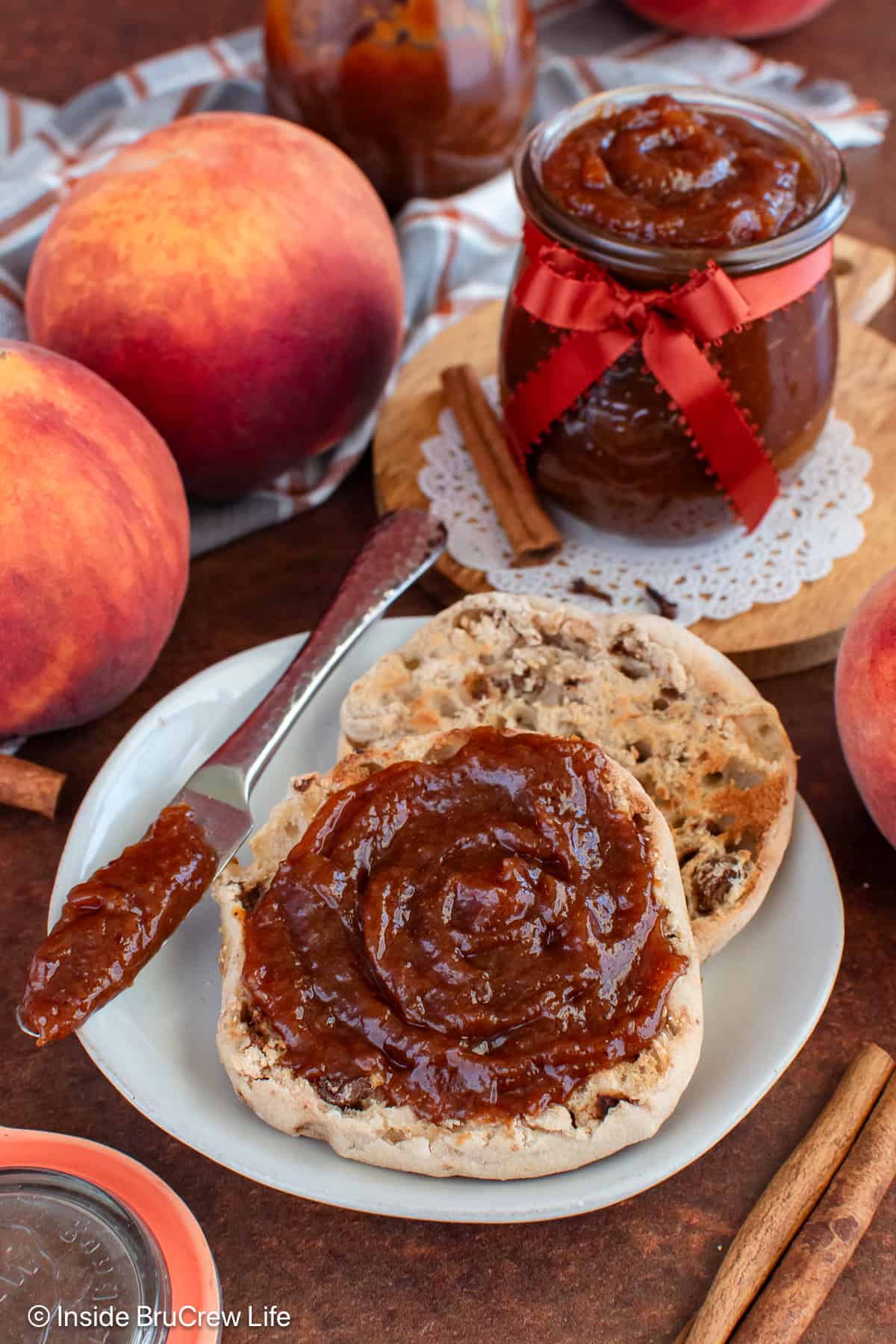 An English muffin with peach butter on it.