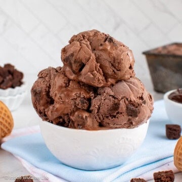 A white bowl filled with scoops of chocolate brownie ice cream.