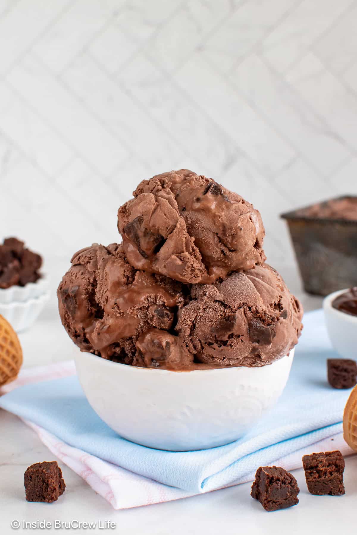 A white bowl filled with scoops of chocolate brownie ice cream.
