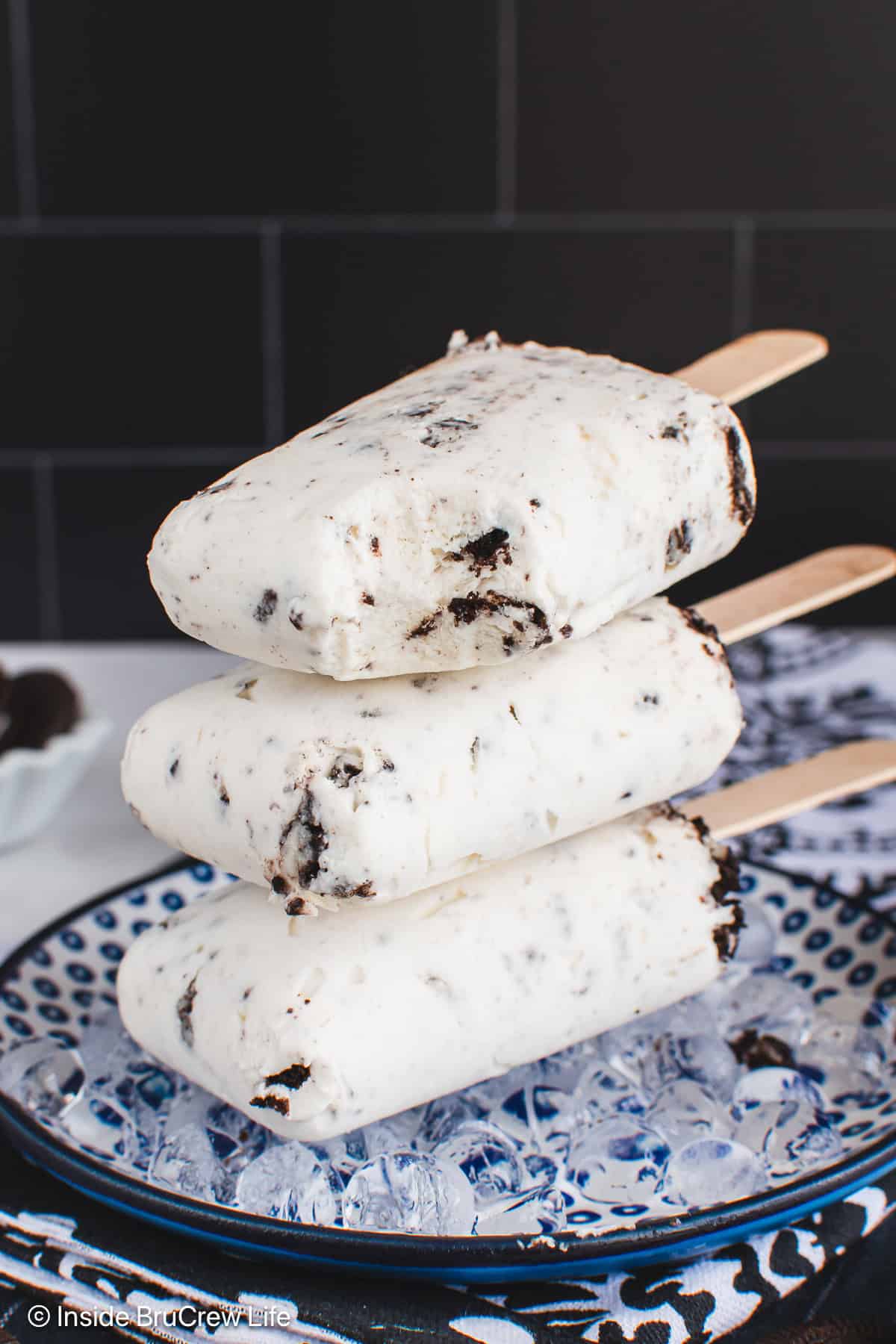 A stack of three yogurt cookies and cream popsicles stacked on a plate.