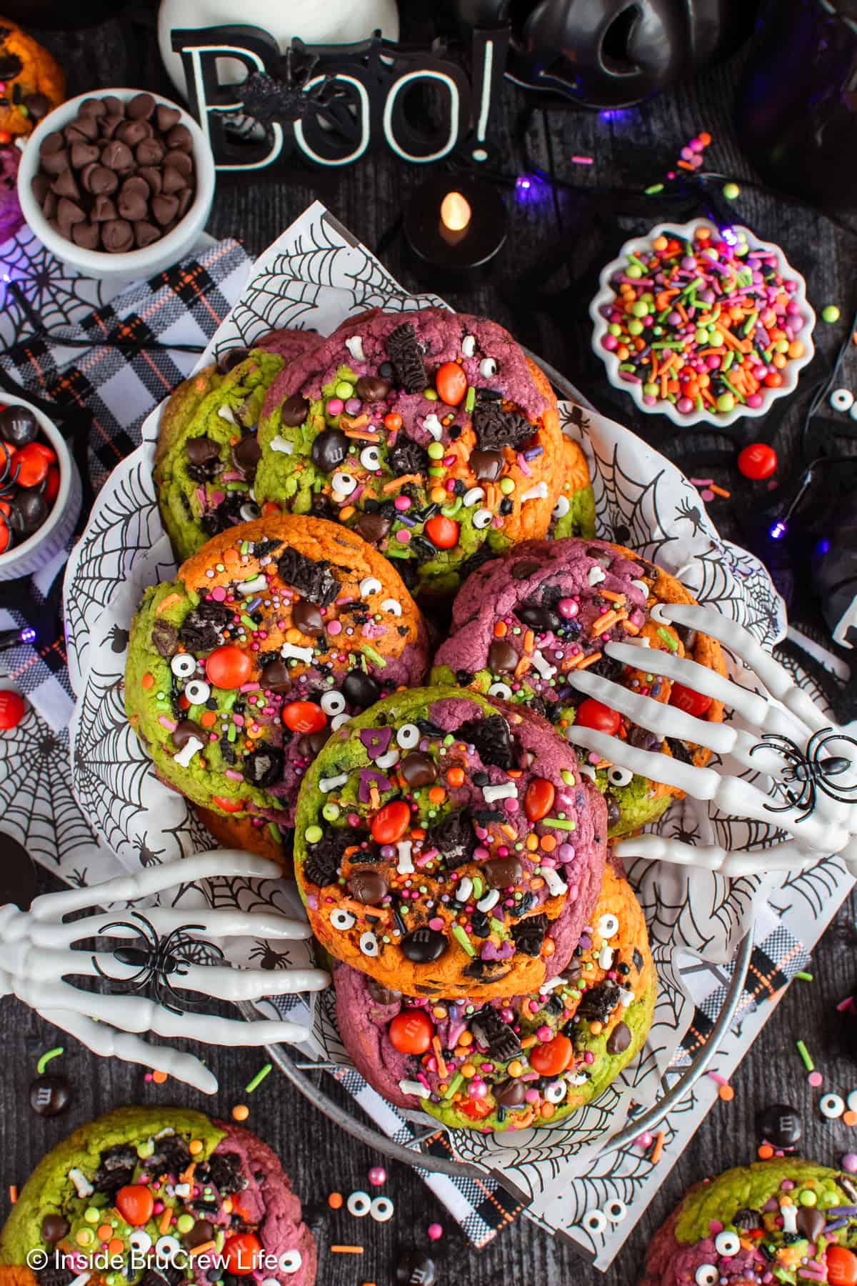 Halloween chocolate chip cookies in a basket with spooky decorations around it.