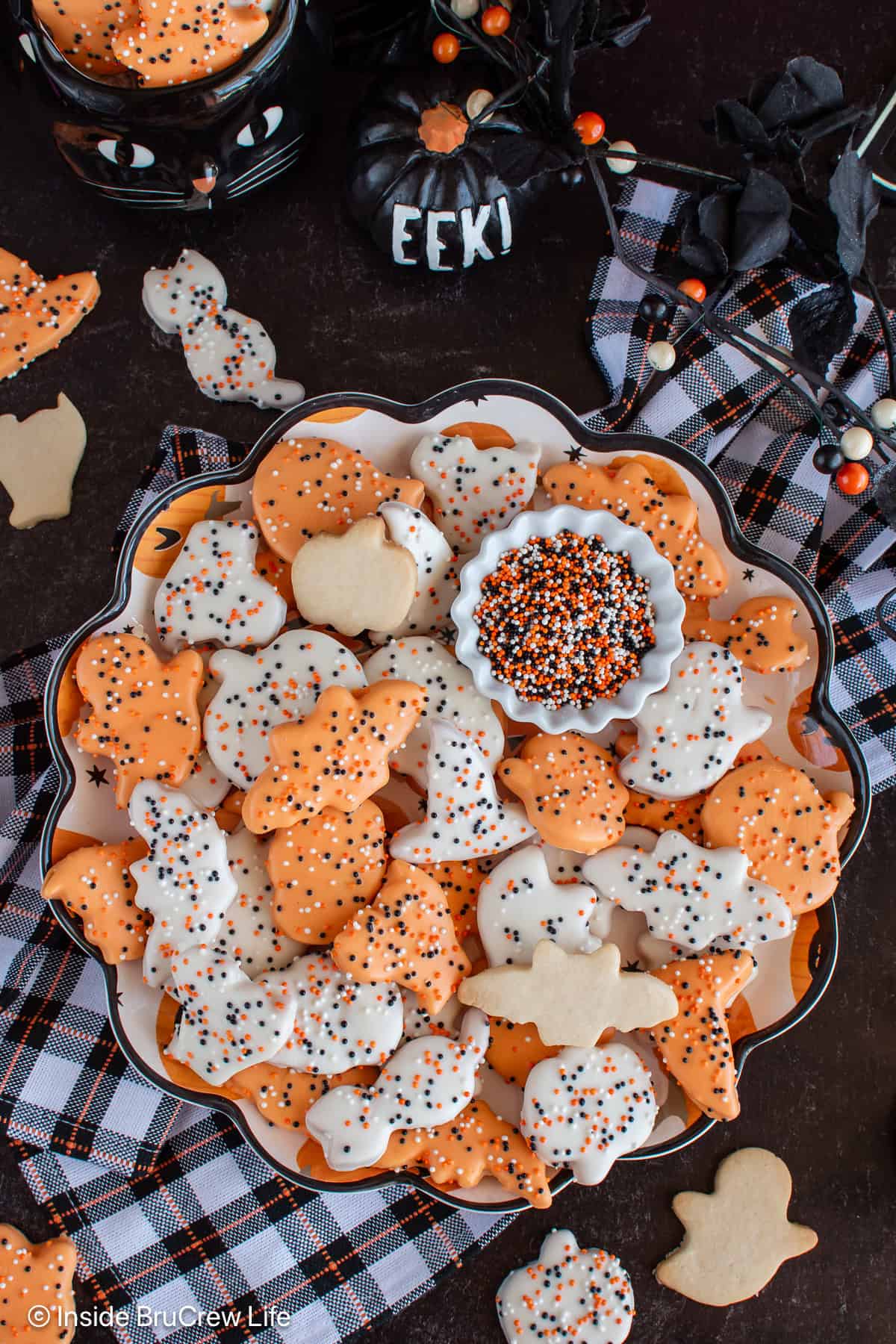A round black tray filled with Halloween animal cookies.