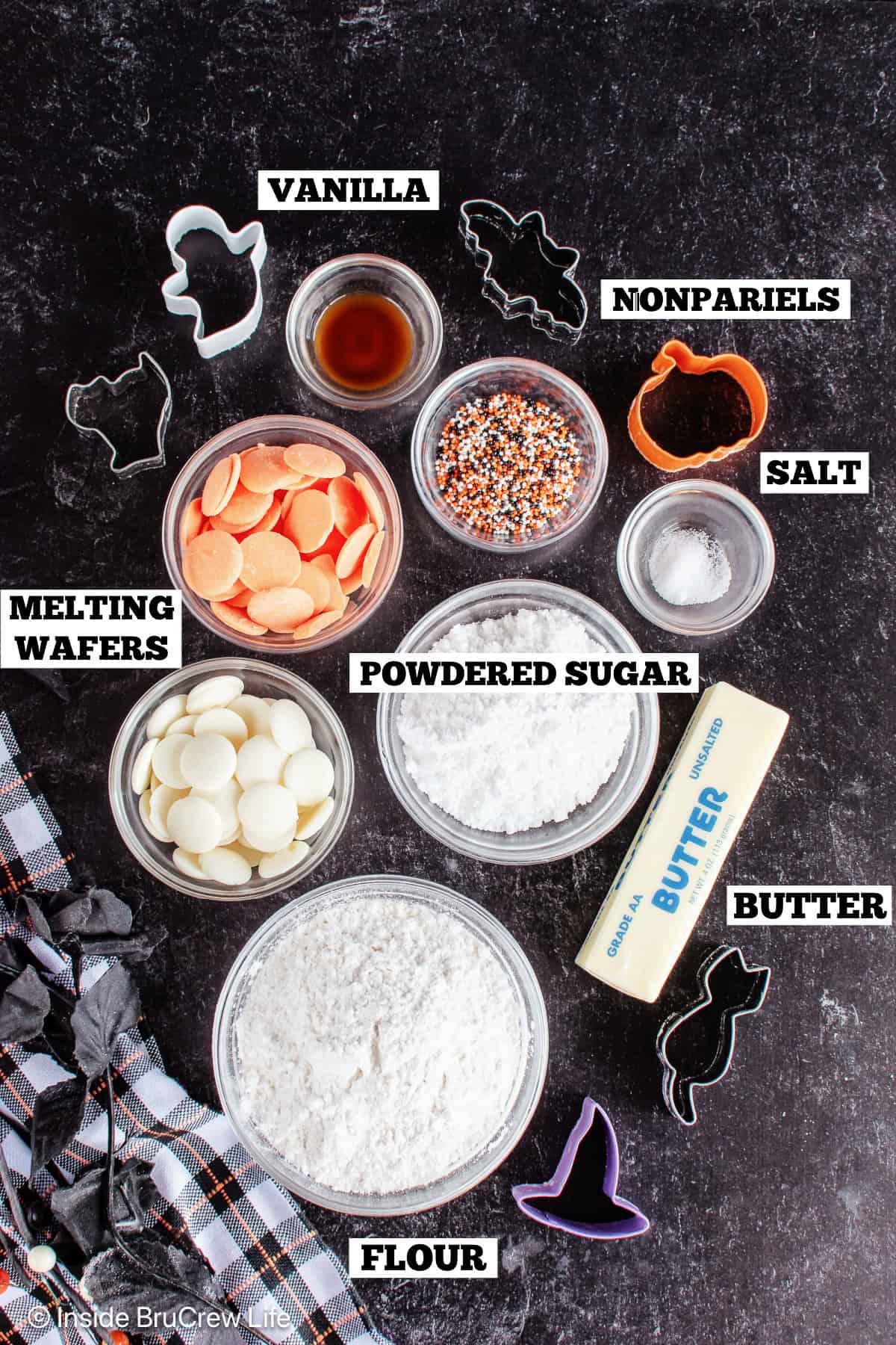 Ingredients for frosted animal cookies on a black board with text labels.