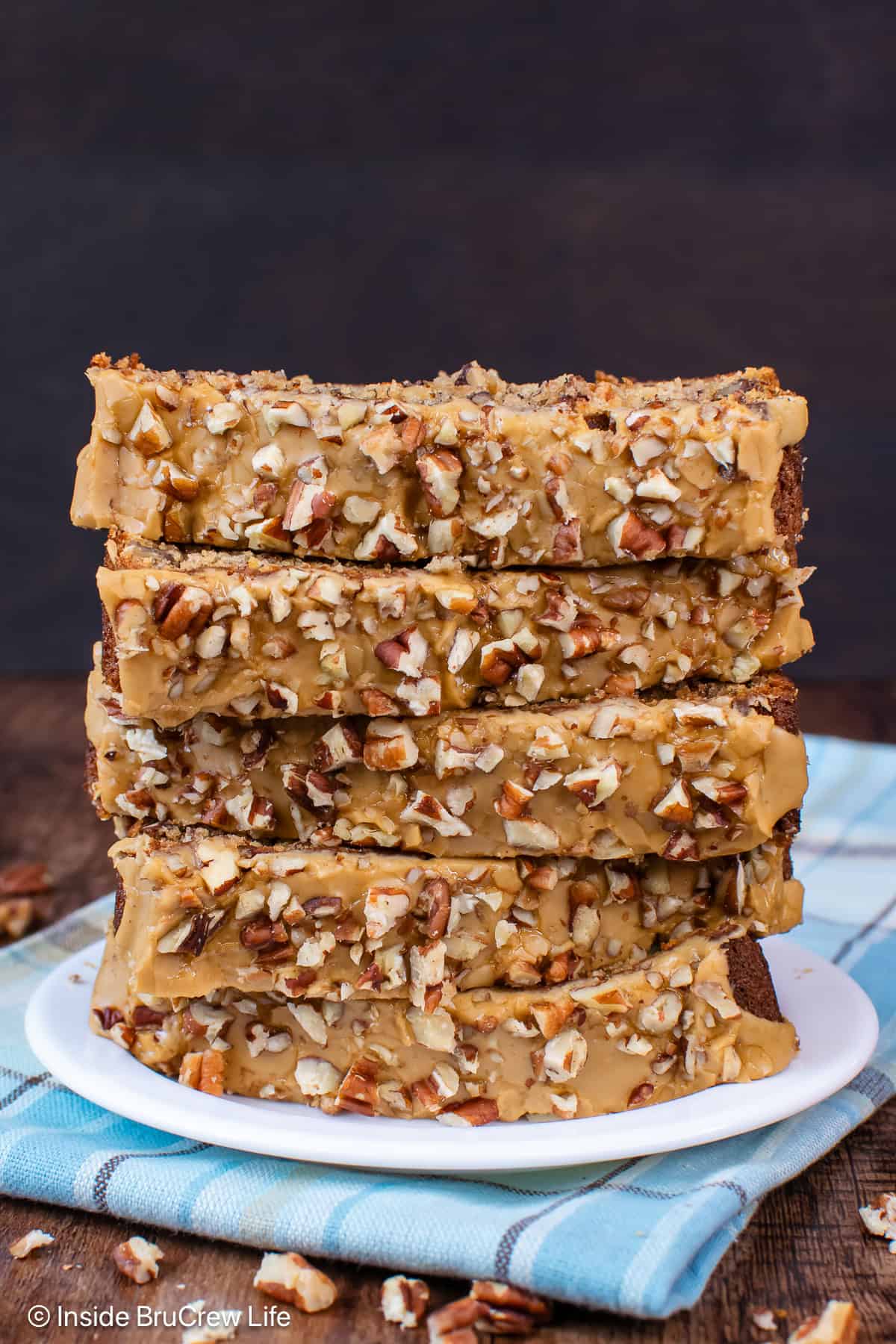 A stack of pecan banana bread with a maple glaze on a plate.